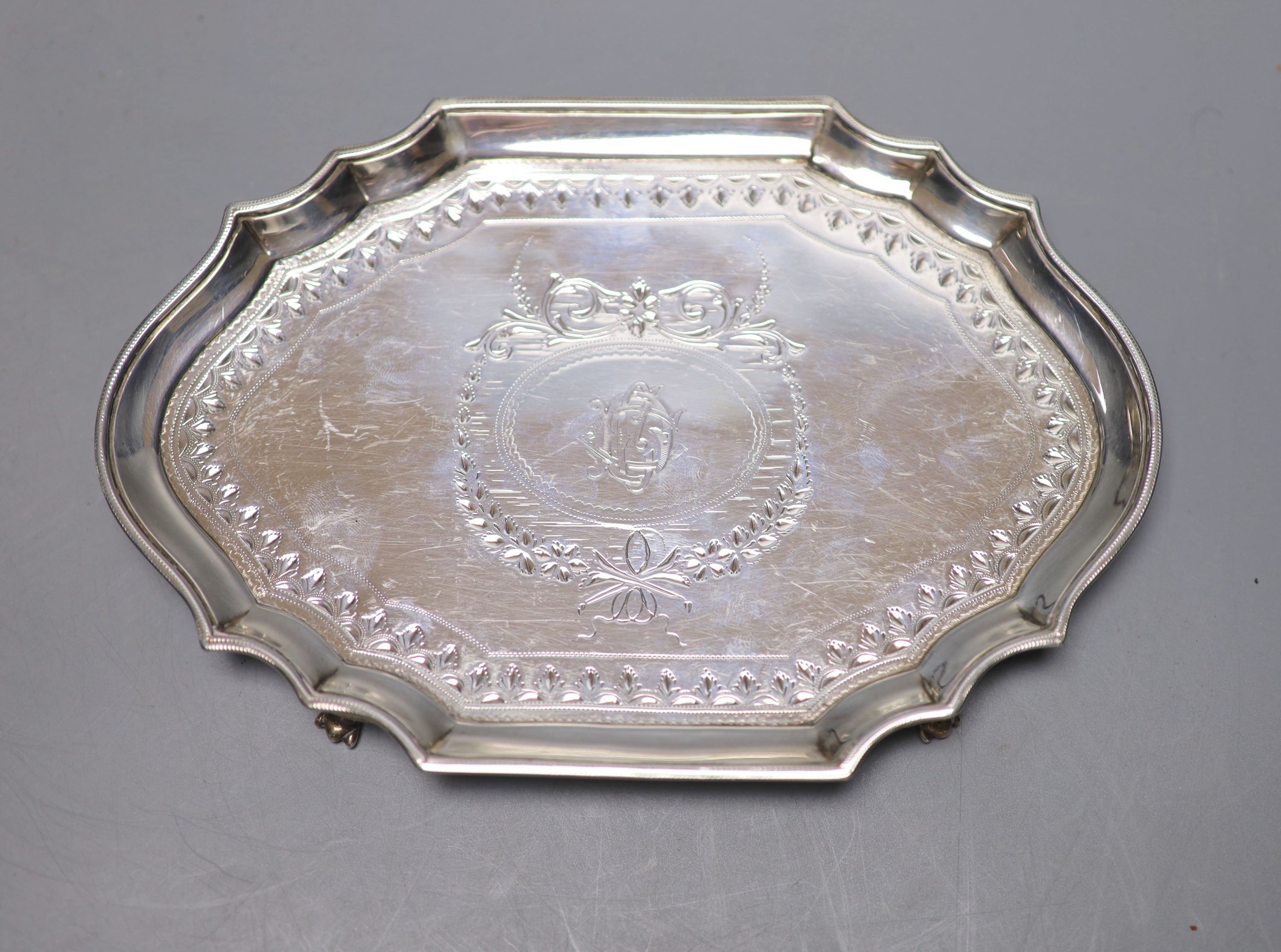 A George III bright cut engraved oval teapot and matching stand, Soloman Hougham, London, 1794, stand 19.3 cm, gross 20oz.